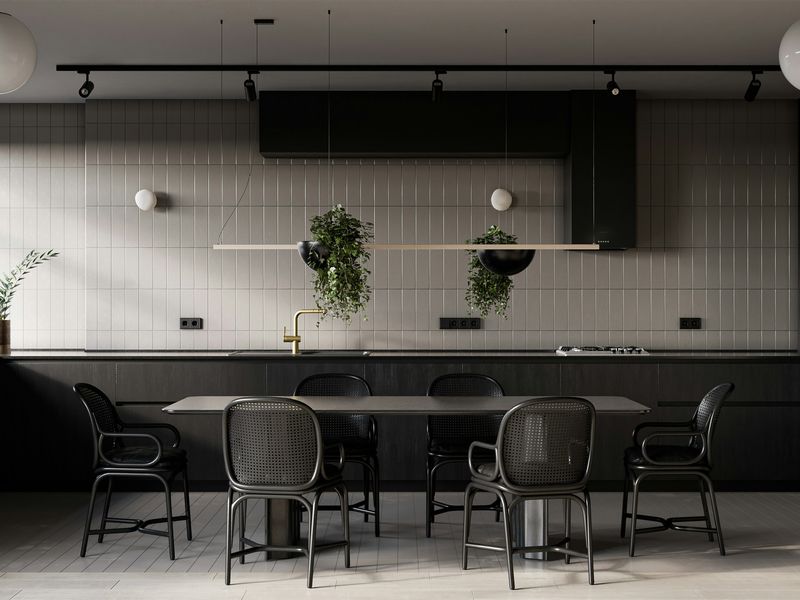 Black cabinets, white brick and a long table