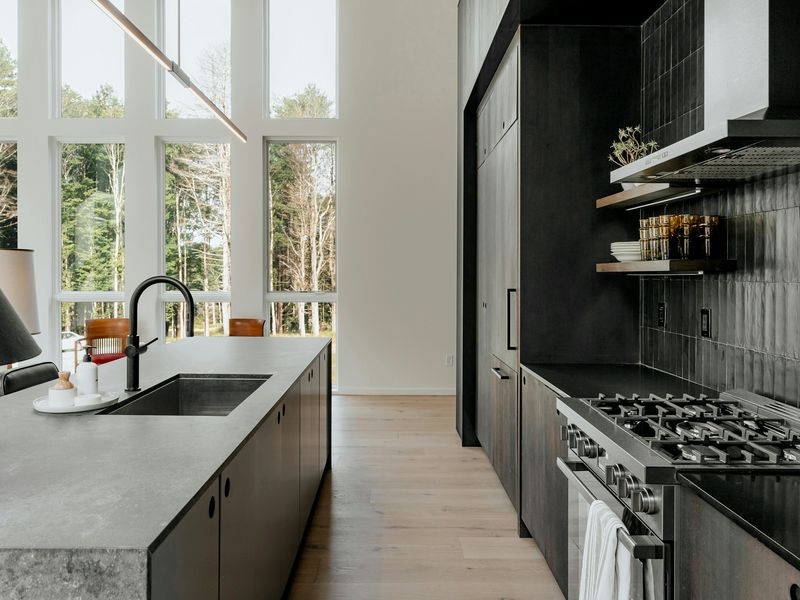 Dark cabinets, a concrete-look island and a tall window