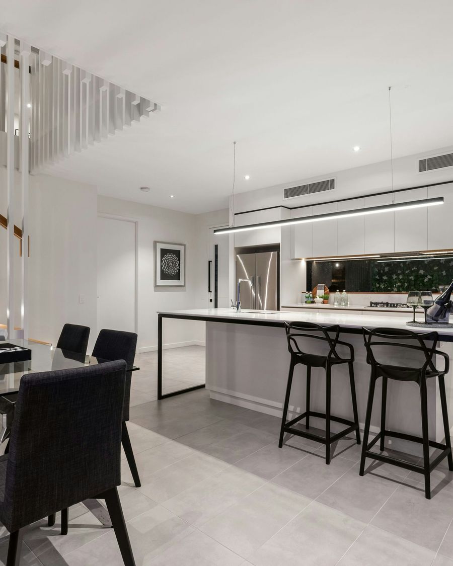 White cabinets with black stools at the counter