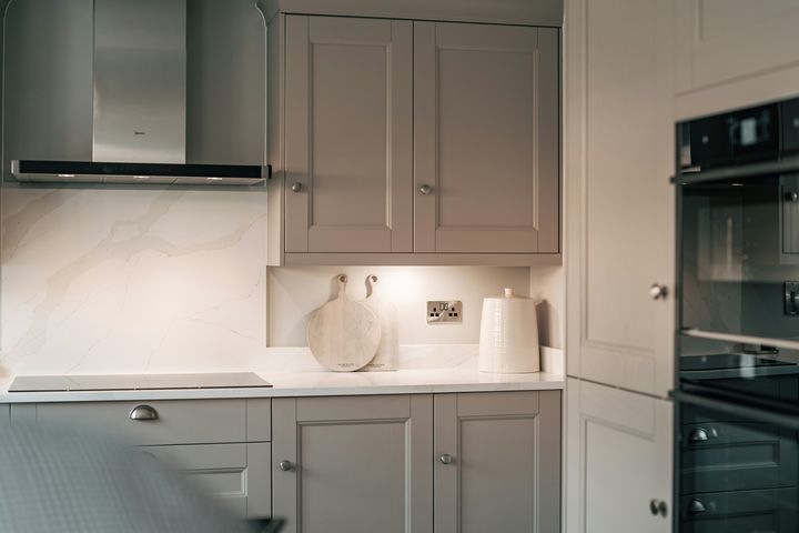 Gray Shaker cabinet doors beside a black oven